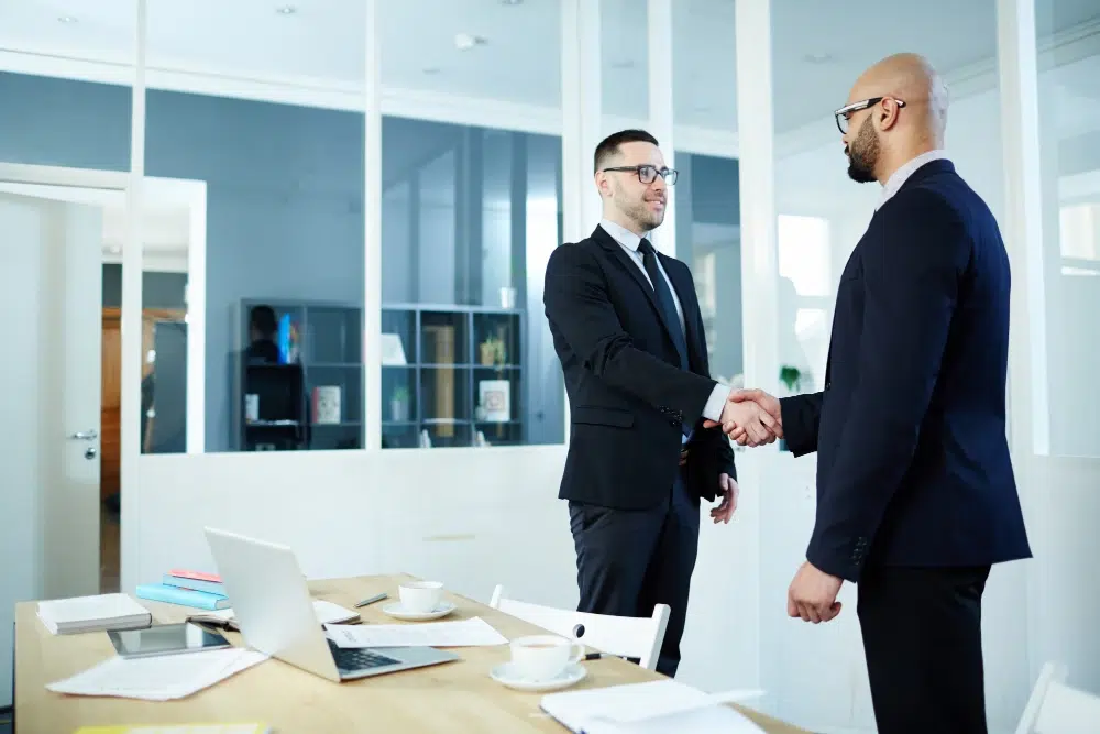 Two businessmen shaking hands in a office - M&A advisory Australia