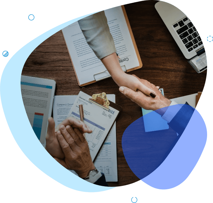 Business professionals shaking hands over financial documents, representing mergers and acquisitions agreement - M&A advisory Australia